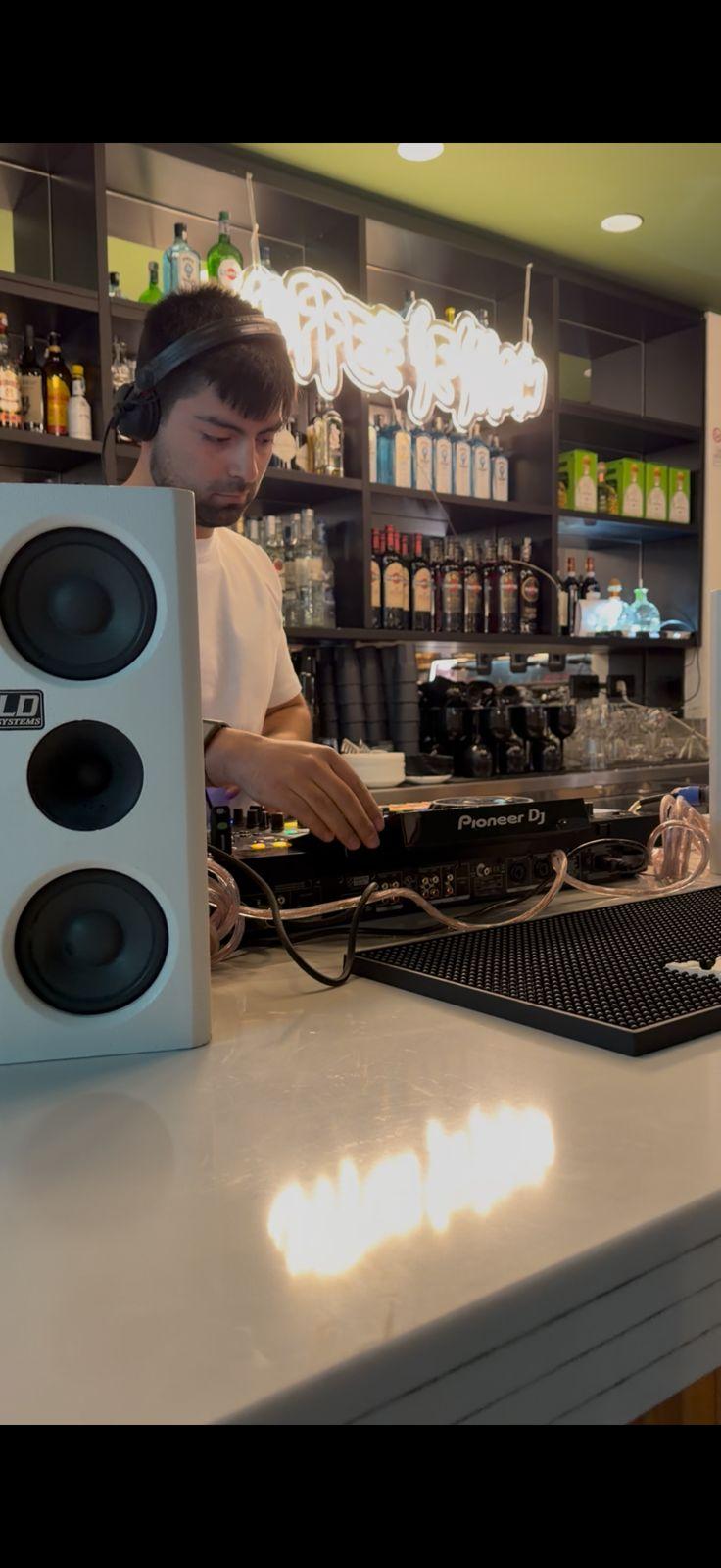 Matti en Coffee Session, polera blanca, mezclando